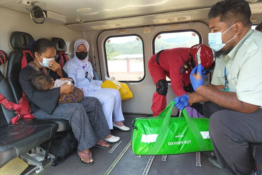 Anggota Unit Udara JBPM membawa keluar pesakit Orang Asli untuk ke Hospital Gua Musang. - Foto ihsan JBPM