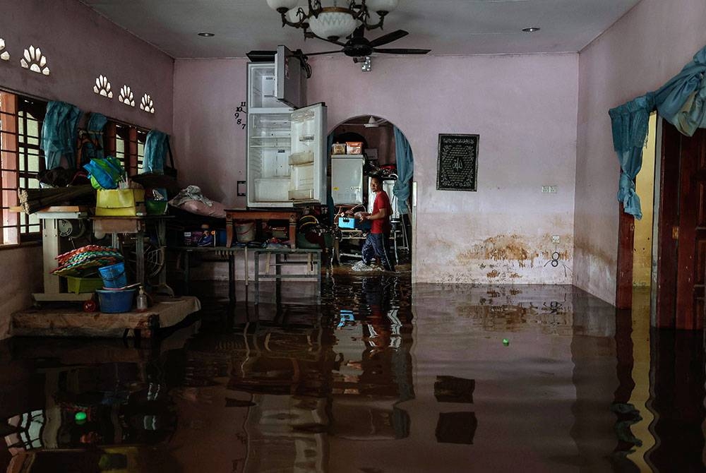 Penduduk kampung sedang giat melakukan kerja-kerja pembersihan selepas banjir surut ketika tinjauan di sekitar perkampungan di Yong Peng. -Foto Bernama