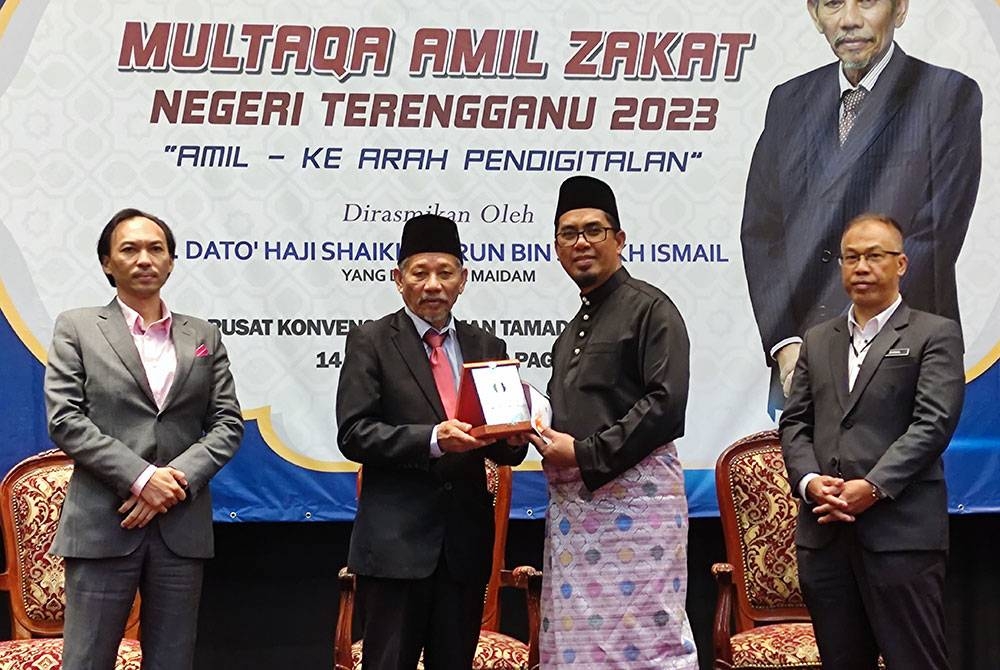 Shaikh Harun (dua dari kiri) menyampaikan anugerah perkhidmatan amil kepada seorang amil pada Multaqa Amil Zakat Negeri Terengganu 2023 di Taman Tamadun Islam (TTI) pada Selasa.