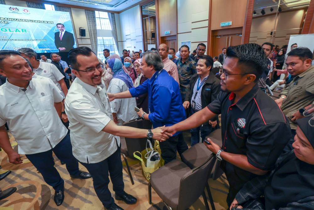 Asyraf Wajdi beramah mesra dengan usahawan selepas merasmikan Program Pembangunan Usahawan Teknikal Solar (ProSolar) hari ini. - Foto Bernama