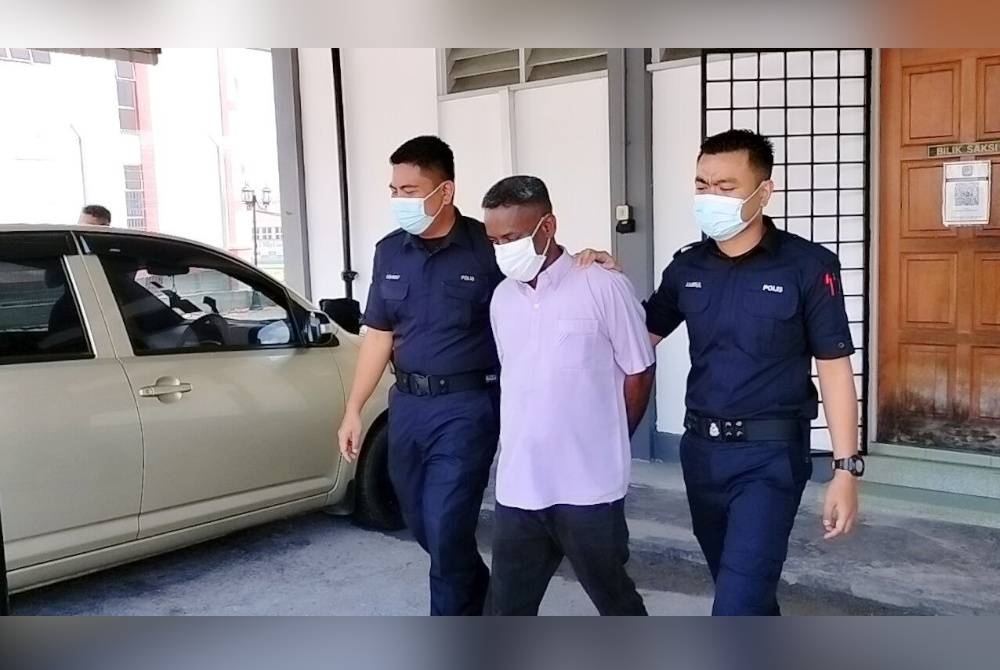 Anggota polis mengiringi tertuduh keluar selepas mahkamah menjatuhi hukuman penjara.