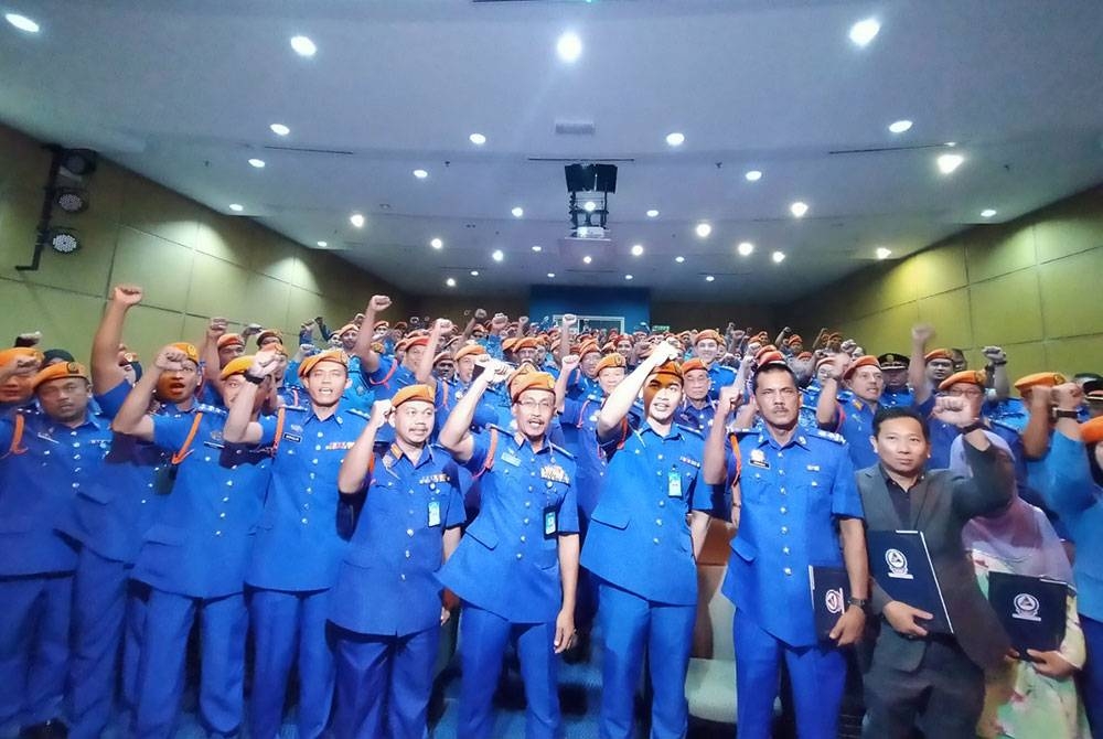 Aminurrahim (lima dari kanan) bersama-sama pegawai dan anggota APM Perak selepas menyempurnakan Majlis Perhimpunan Setia Peringkat APM Perak di Auditorium Kompleks Kementerian Dalam Negeri, Bandar Meru Raya pada Rabu.