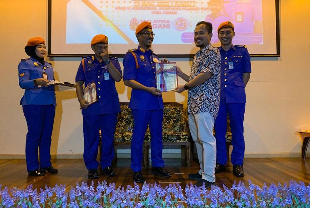 Aminurrahim (tengah) menyampaikan Sijil Penghargaan kepada Ketua Biro Sinar Harian, Saifullah Ahmad ketika Majlis Perhimpunan Setia Peringkat APM Perak di Auditorium Kompleks Kementerian Dalam Negeri, Bandar Meru Raya pada Rabu.