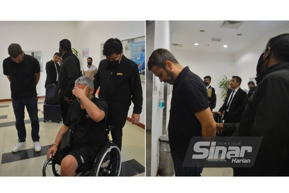 Dua warga UK, Andrew Mark Peters (berkerusi roda) dan Darren Anthony Mcnicholas diiringi oleh snggota SPRM) untuk didakwa berhubung Op Tropicana di Mahkamah Shah Alam. - Foto Sinar Harian ASRIL ASWANDI SHUKOR