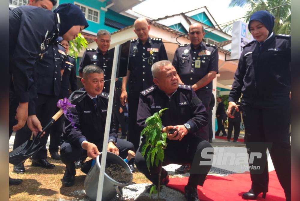 Abd Jalil (kanan) melakukan simbolik pelancaran dengan menanam pokok di pekarangan CIC di Pengkalan Chepa, Kota Bharu.