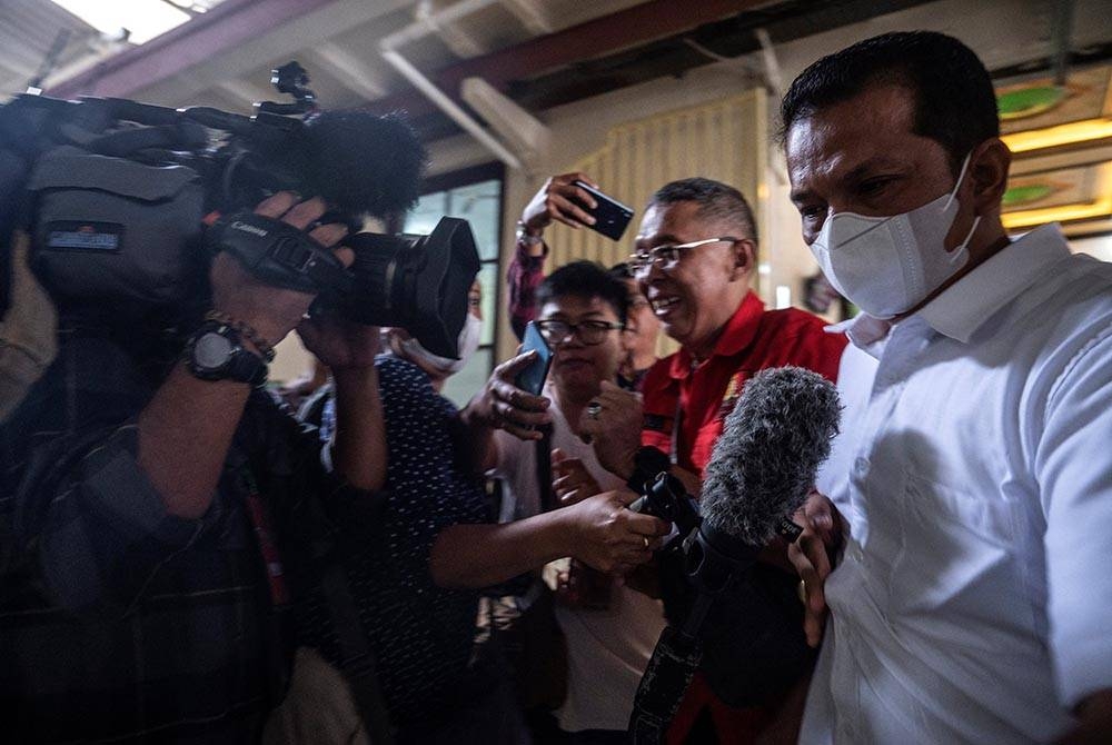 Hasdarmawan (kanan) tiba di mahkamah di Surabaya untuk mendengar keputusan hukuman berkaitan kes rempuhan stadium di bandar Malang, Indonesia. - AFP