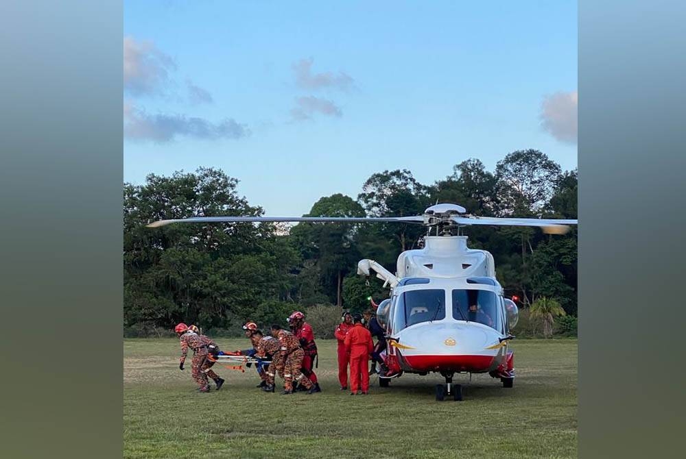 Anggota bomba membawa Muhammad Nazli yang tidak sedarkan diri kerana dipercayai keracunan makanan di Gunung Gelemat, Kuala Jengai, di Hulu Dungun, petang Khamis.