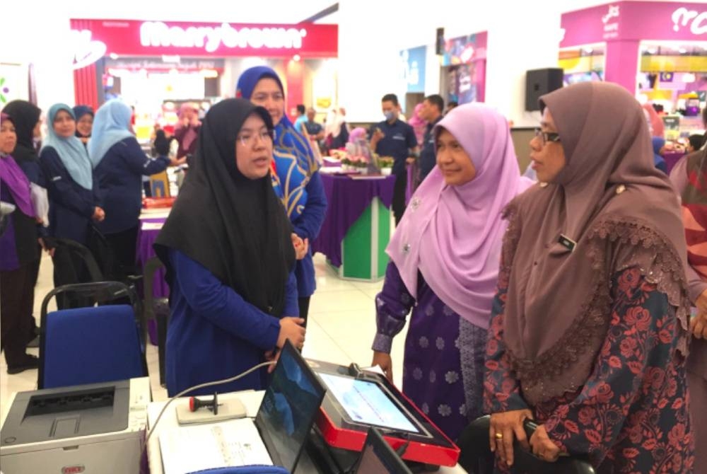 Aiman Athirah (kanan) melawat ke gerai pameran yang diadakan di Tunjong, Kota Bharu.