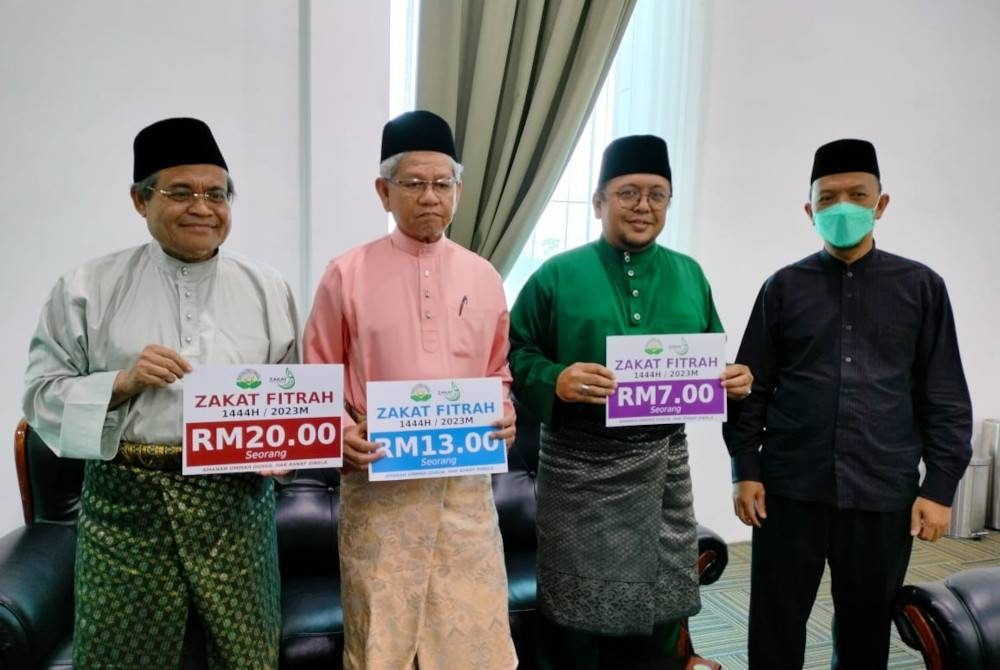 Ahmad Zakiyuddin (dua dari kiri) bersama Amran (dua dari kanan) dan Samsudin (kiri) menunjukkan kadar zakat fitrah bagi Pulau Pinang pada tahun ini.