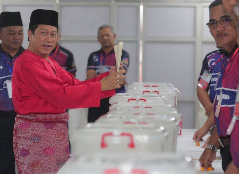 Ahmad (kiri) membuang undi di Dewan Jubli Intan Pontian pada Sabtu.