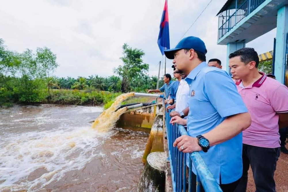 Onn Hafiz (depan) meninjau operasi pengepaman air banjir di Parit Jelutong, Pintu Air Sungai Senggarang, pada Sabtu. - Foto Facebook Onn Hafiz