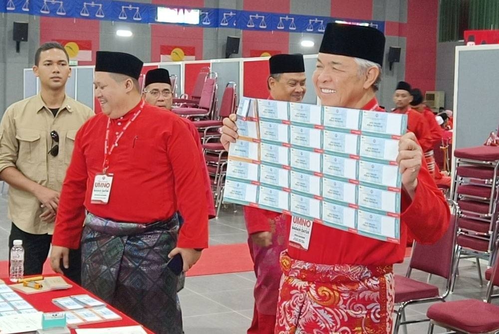 Ahmad Zahid menunjukkan kertas undi sebelum memilih pada Mesyuarat Perwakilan UMNO Bahagian Bagan Datuk pada Sabtu.