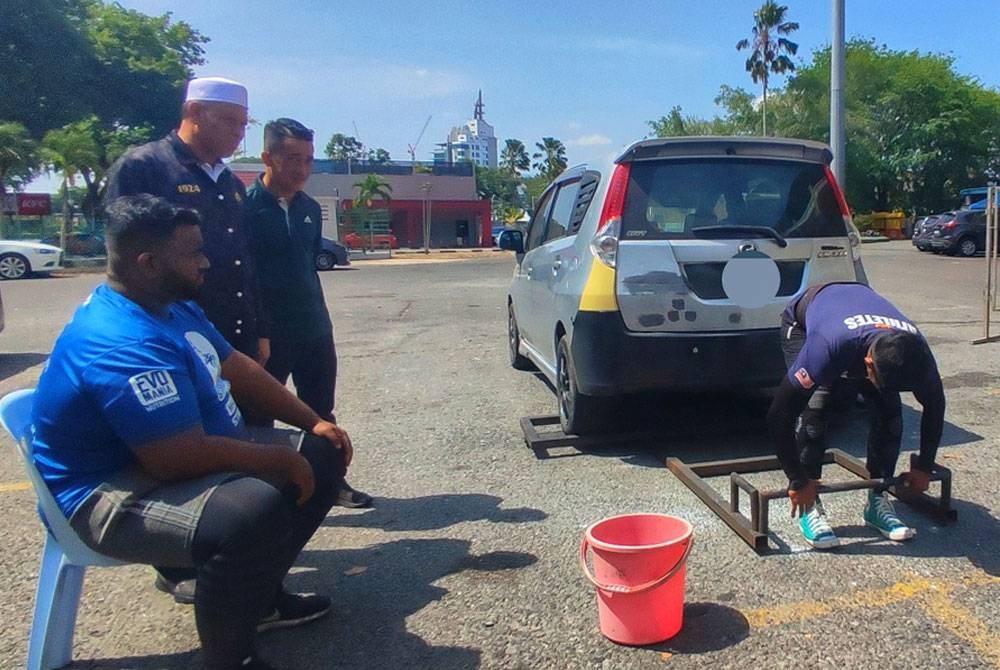 Exco Penerangan, Komunikasi dan Multimedia Kedah, Datuk Wan Romani Wan Salin (kiri, berdiri) menyaksikan peserta mengangkat kereta pada &#039;Kedah Strongest Man & Woman 2023&#039; di perkarangan Stadium Darul Aman, di sini, pada Sabtu.