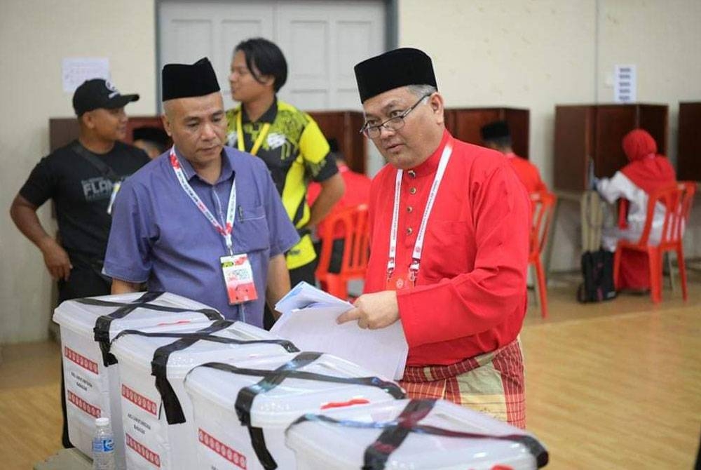 Shamsul Anuar (kanan) membuang undi sempena pemilihan UMNO ketika Mesyuarat Perwakilan UMNO Bahagian Lenggong di Dewan Kolej Kemahiran Tinggi Mara Lenggong di sini pada Sabtu. - Foto FB DR SHAMSUL ANUAR NASARAH