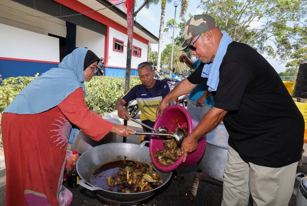 Mangsa banjir, Suriyani Arbain, 57, (kiri) bersama Jemari Katimon, 66, (dua dari kiri) dan rakan-rakan bergotong-royong menyediakan makanan tengah hari untuk mangsa banjir di PPS Dewan Orang Ramai Sri Medan pada Rabu. - Foto Bernama