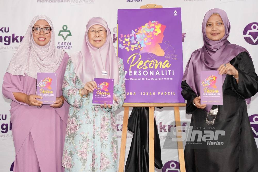 Wan Azizah melancarkan buku Pesona Personaliti sambil diperhatikan oleh Firdaus dan Muna Izzah yang diadakan di Kompleks Karangkraf pada Sabtu.