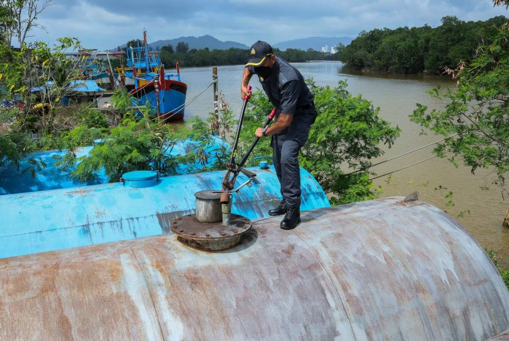 Anggota Penguatkuasa Negeri KPDN Pahang memotong kunci pada tangki simpanan diesel berisi minyak diesel bersubsidi yang berjaya dirampas oleh KPDN Pahang dalam Ops Tiris pada 10 Mac lalu.