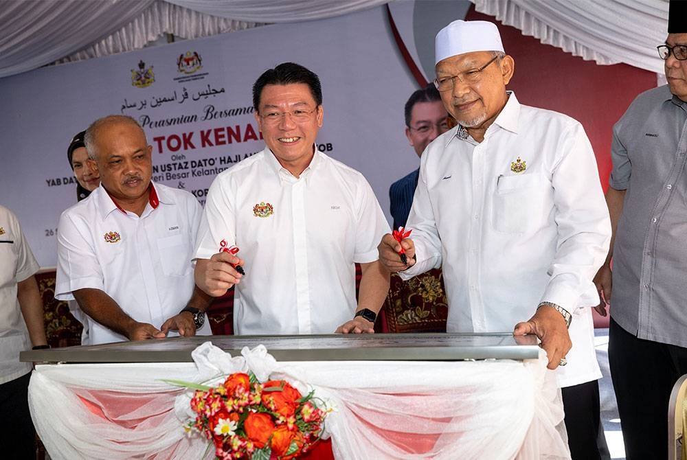 Kor Ming (dua dari kiri) bersama Ahmad (tiga dari kiri) menandatangani plak perasmian Pasar Tok Kenali, Binjai pada Ahad. - Foto Bernama