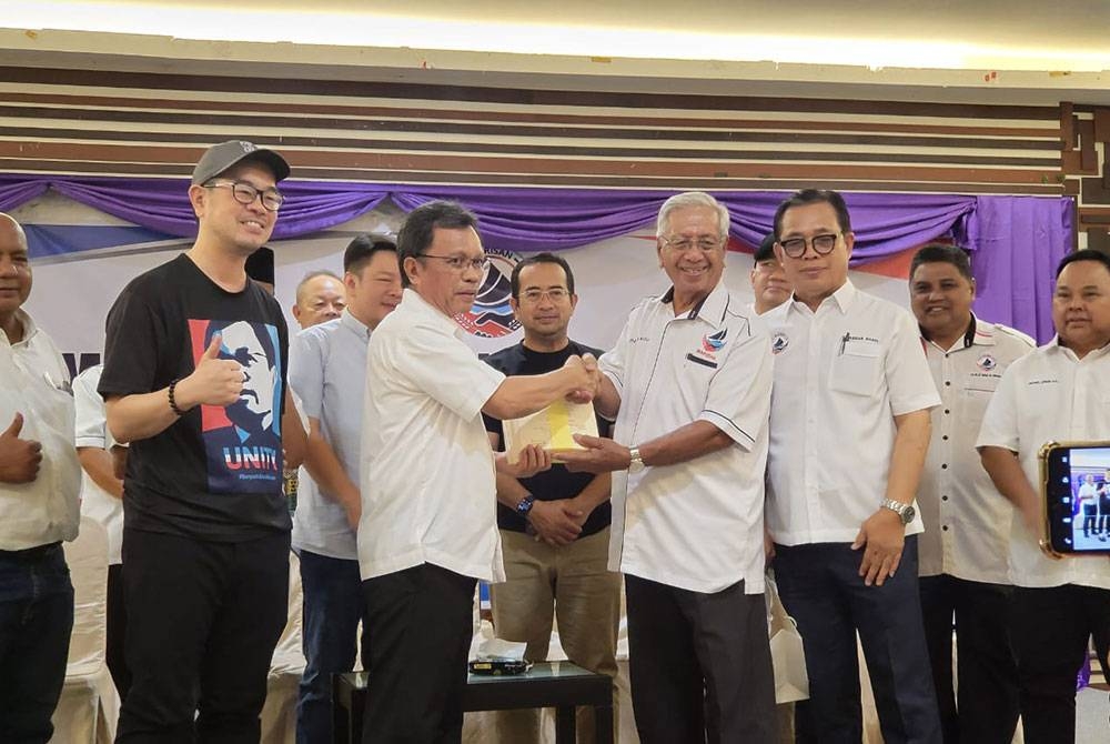 Mohd Shafie menyampaikan watikah pelantikan sebagai penaja kepada Uda dalam Program Bersama Akar Umbi Putatan di Putatan.