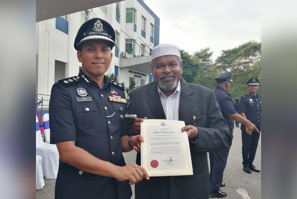 Hakimsa (kanan) bergambar kenangan dengan Mohd Iqbal bersama sijil penghargaan yang diterima sempena sambutan Hari Polis ke-216 IPD Shah Alam pada Isnin.