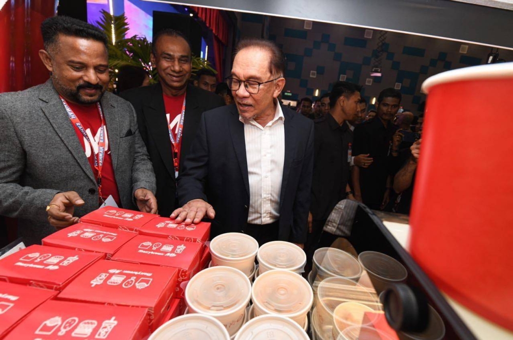 Anwar meninjau makanan sempena Kenduri Menu Rahmah yang berlangsung di Dewan Serbaguna Parlimen pada Isnin. - Foto KPDN