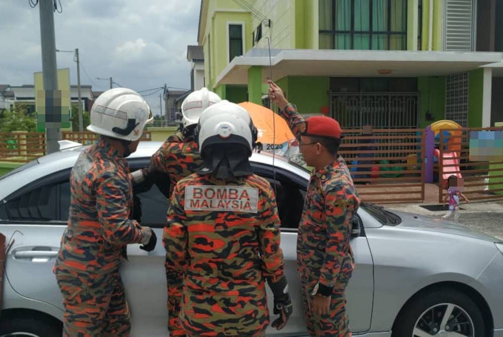 Bomba menyelamatkan seorang bayi perempuan selepas dikatakan terkunci dalam kereta di Taman Saujana, Sepang pada Isnin. - Foto Bomba Selangor