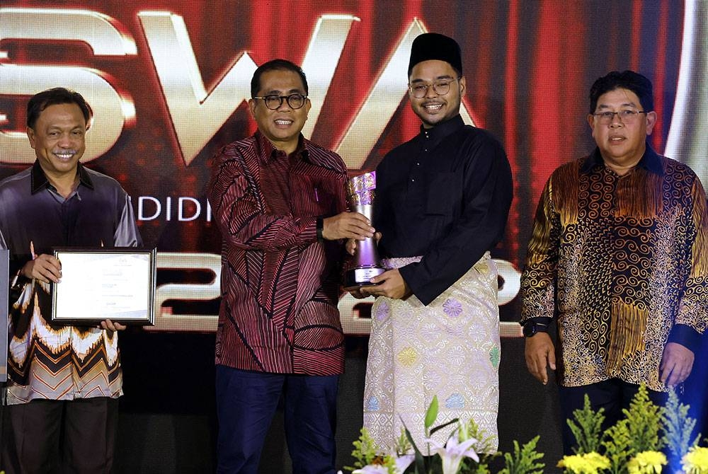 Mohamed Khaled (dua dari kiri) menyampaikan Anugerah Tokoh Siswa kepada Mifzal Salihin (dua dari kanan) pada Majlis Anugerah Tokoh Siswa 2022 di Kementerian Pengajian Tinggi, pada Isnin. - Foto Bernama