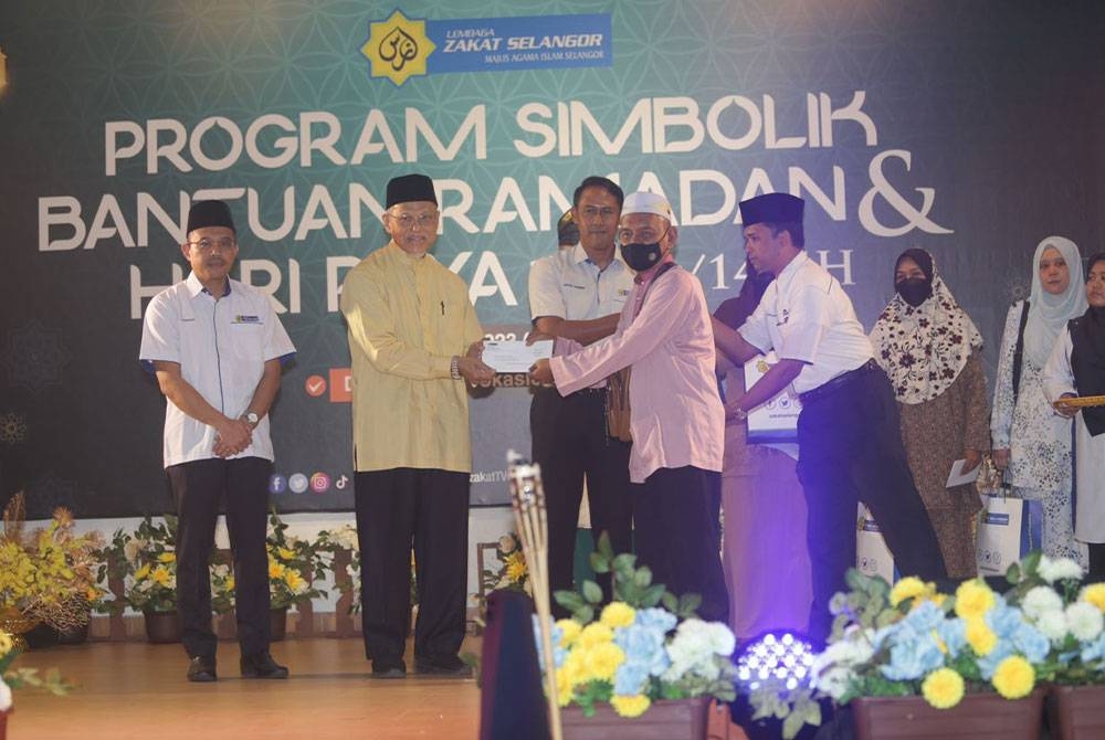 Mohd Tamyes (dua dari kiri) menyampaikan bantuan zakat bagi persediaan Ramadan dan Syawal kepada salah seorang penerima di Dewan Besar Kolej Vokasional Gombak pada Selasa.