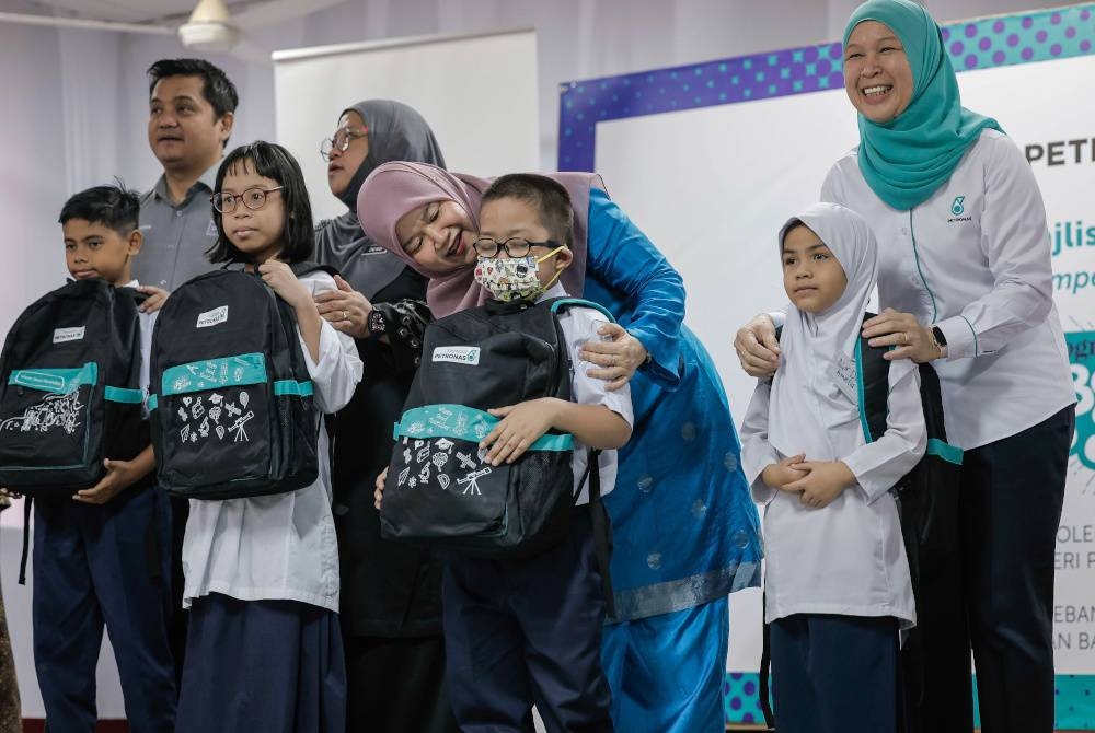 Fadhlina (lima dari kiri) menyantuni murid-murid berkeperluan pendidikan khas pada Majlis Penyerahan Pek Kembali ke Sekolah Yayasan Petronas 2023 di Sekolah Pendidikan Khas Jalan Batu (L) Jalan Raja Laut pada Rabu. - Foto Bernama