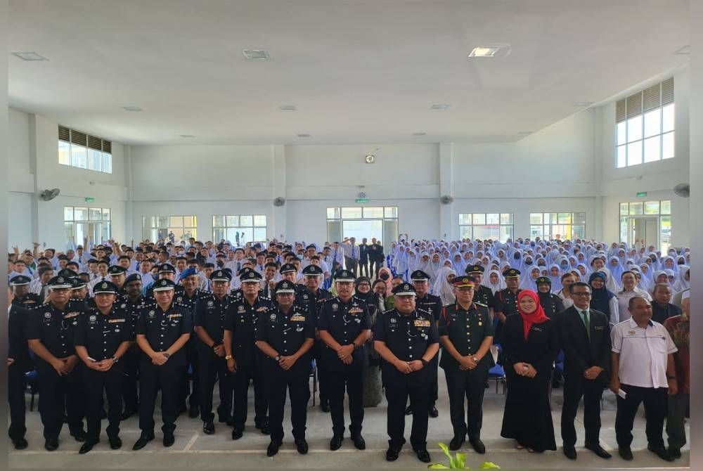 Idris bergambar bersama pelajar dan warga SMK Petagas ketika hadir pada Program Hari Pertama Bersekolah di Putatan.