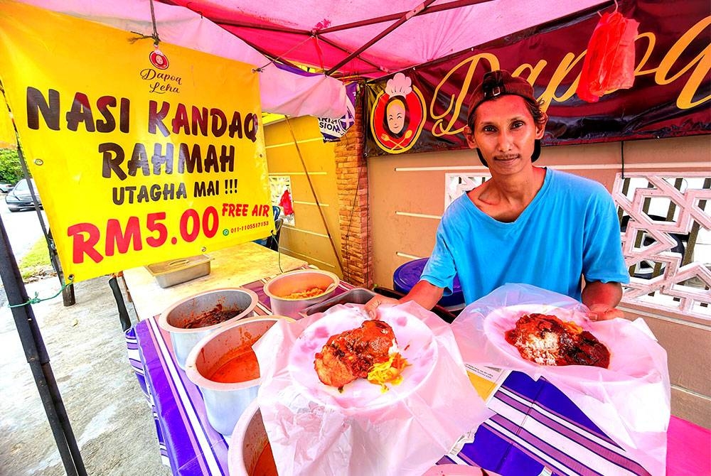 Syahril Huda menunjukkan Nasi Kandar Rahmah RM5 yang dijual digerainya di Taman Nyior, Seremban.