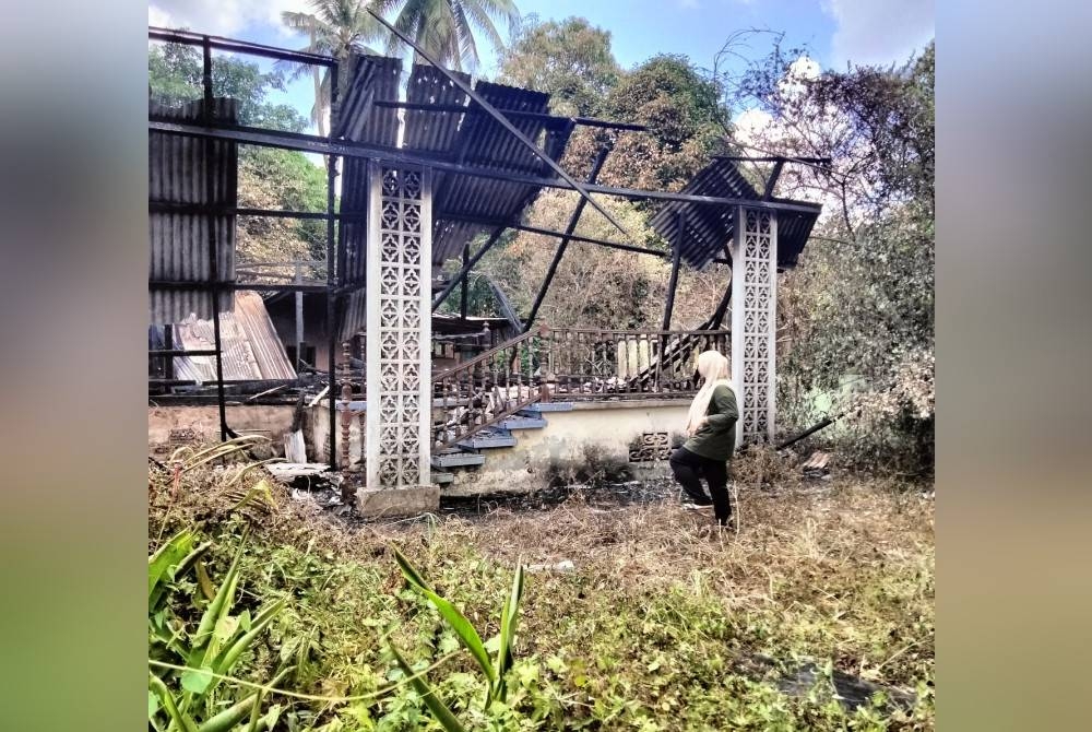 Noor Suhada melihat rumah pusaka Sayed Muhammad Azam yang terbakar pagi Sabtu.