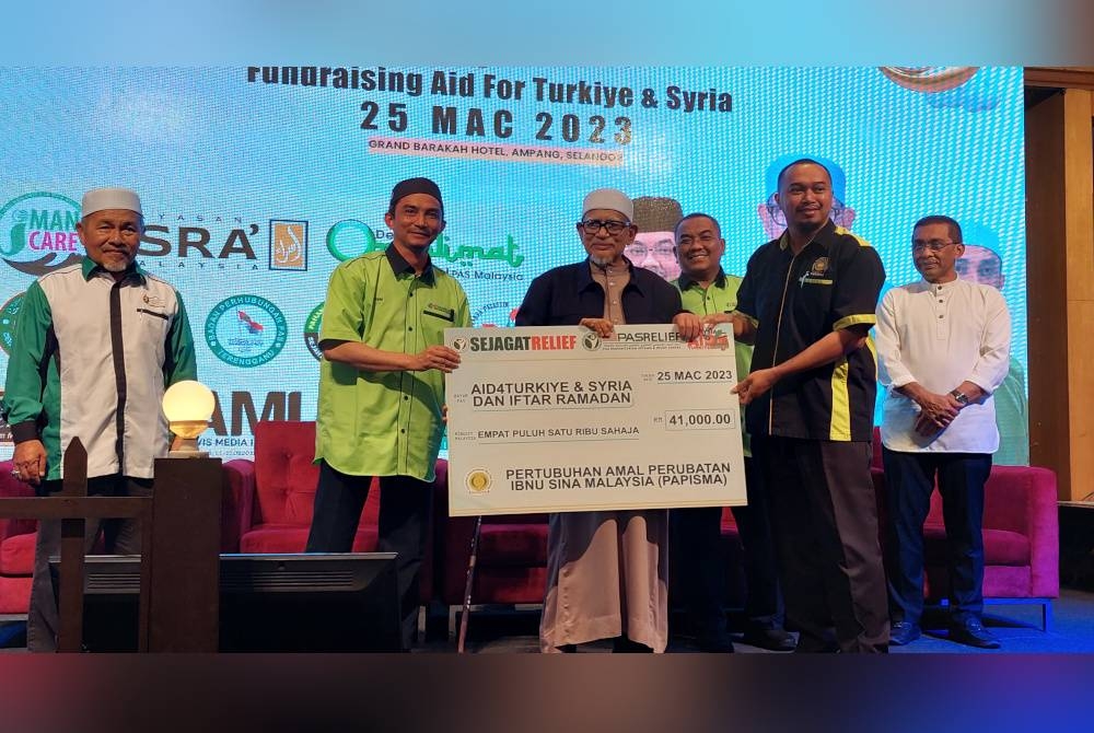 Abdul Hadi menerima replika cek daripada penyumbang dengan diiringi Muhammad Sanusi (tiga dari kanan) ketika Iftar Ramadan sempena Kempen Dana #Aid4Turkiye&Syria di Kuala Lumpur pada Sabtu.