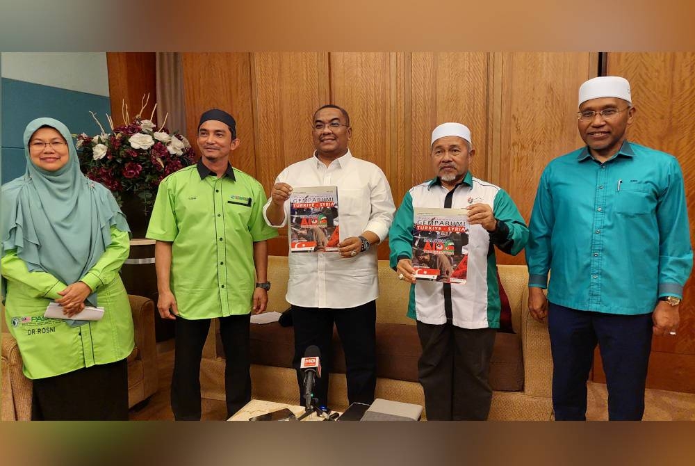 Muhammad Sanusi (tengah), Tuan Ibrahim (dua, kanan) dan tiga lagi pemimpin Pas menunjukkan buku Kempen Dana #Aid4Turkiye&Syria yang digerakkan PasRelief.