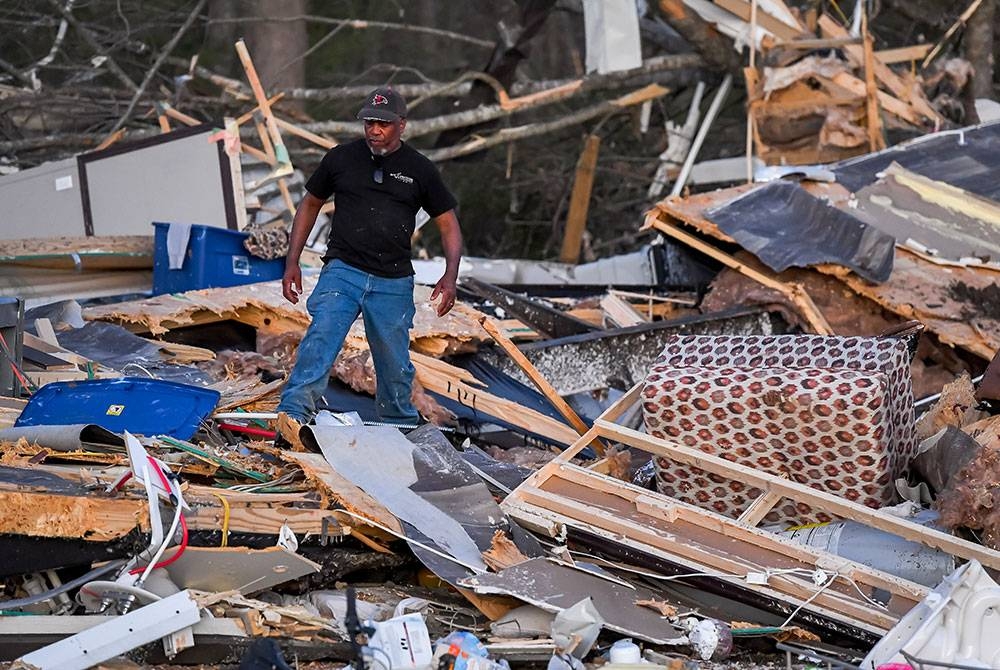 Salah seorang mangsa melihat sisa-sisa rumah yang musnah sehari selepas puting beliung melanda Mississippi. - Foto EPA