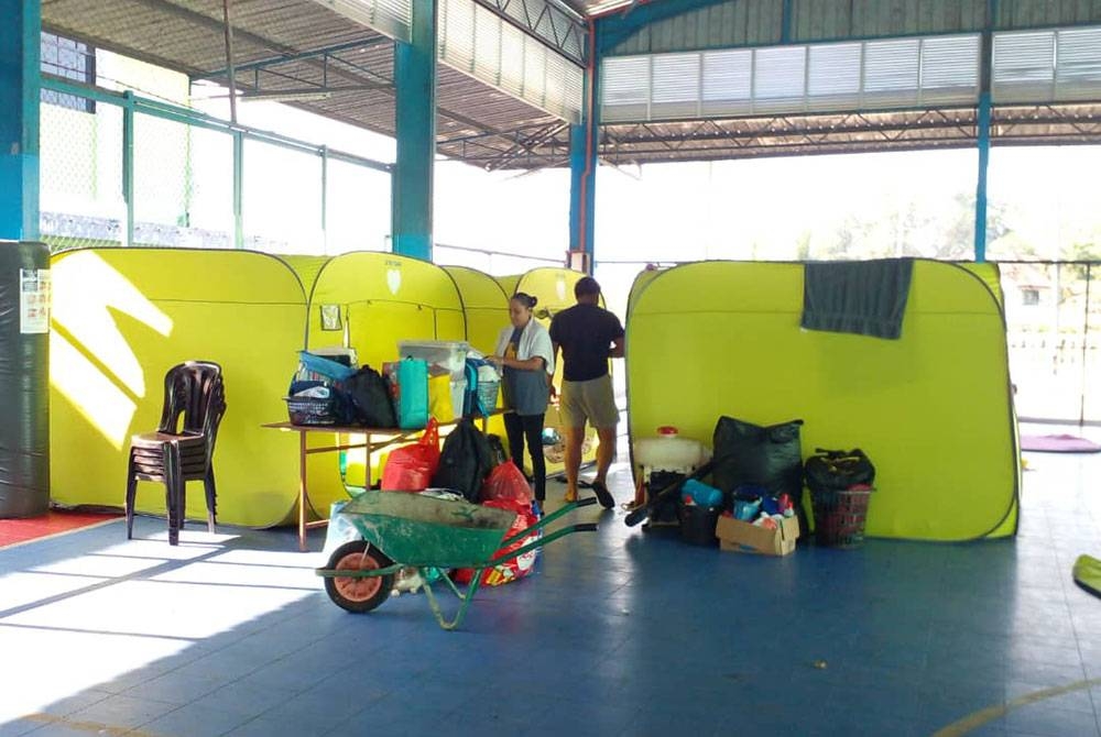 Penduduk yang ditempatkan di PPS Dewan Orang Ramai Yong Peng sedang mengemas barang untuk pulang kediaman masing-masing pada Ahad selepas banjir surut sepenuhnya. - Foto Angkatan Pertahanan Awam Malaysia.