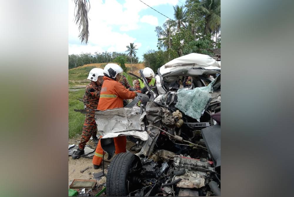 Anggota penyelamat berusaha mengeluarkan mangsa daripada kenderaan yang terlibat kemalangan di KM46, Kampung Selamat, Sungai Tong di Setiu, pada Sabtu. - Foto ihsan bomba