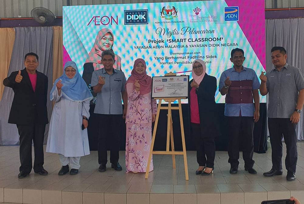 Fadhlina (empat dari kiri) ketika merasmikan Program Smart School yang dianjurkan Yayasan AEON dengan kerjasama Yayaysan Didik Negara di Sekolah Kebangsaan Mengkuang pada Ahad.