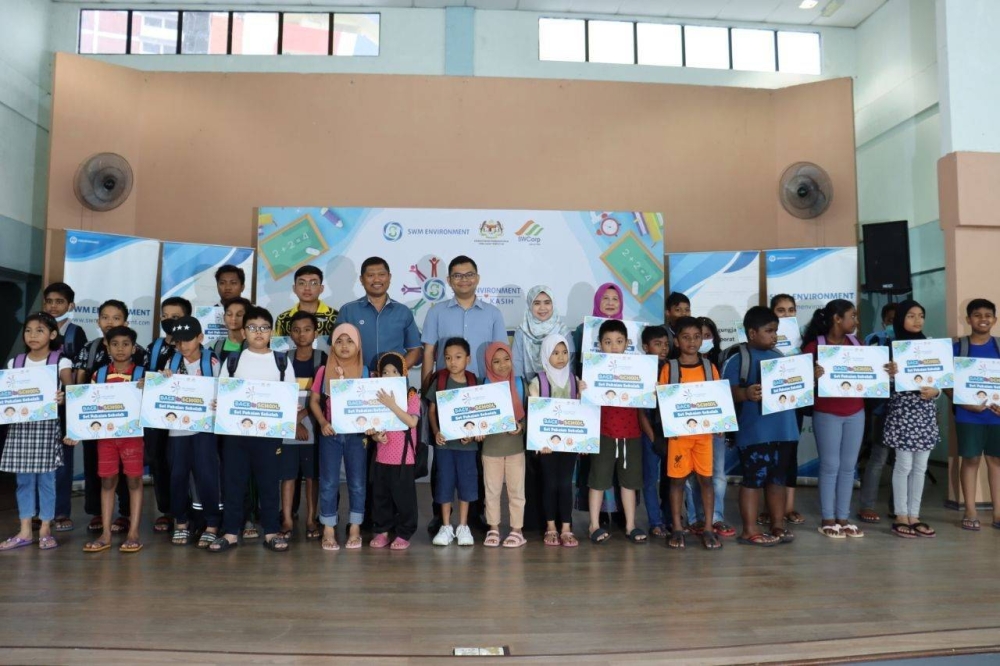 Akmal Nasrullah (berdiri, empat kiri), pada program SWM Kasih Back To School di Dewan Rumah Pangsa Larkin pada Ahad.