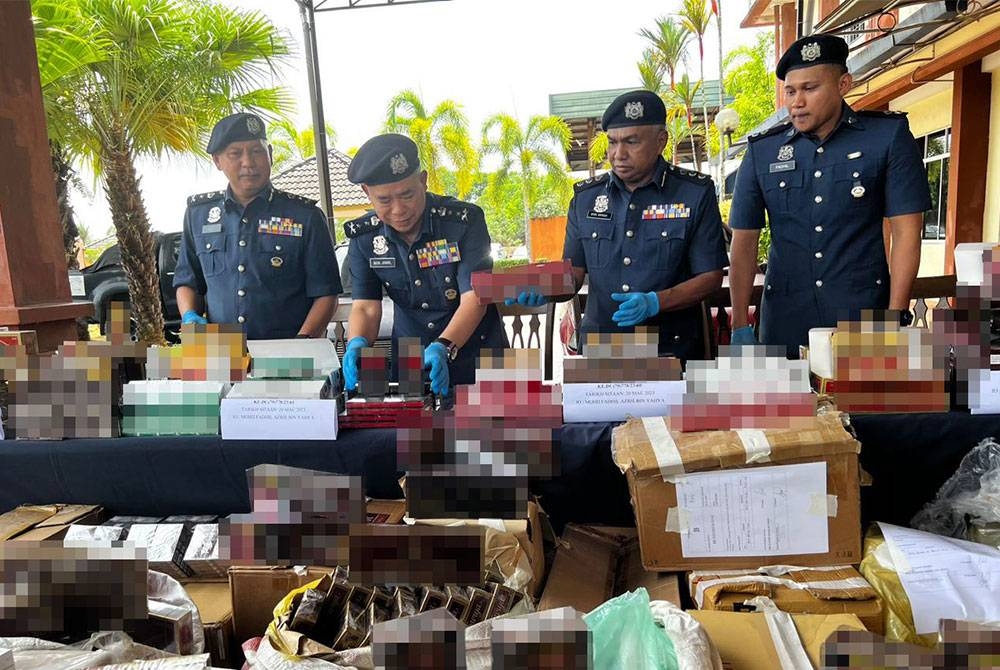 Wan Jamal (dua dari kiri) melihat rokok-rokok seludup yang dirampas.