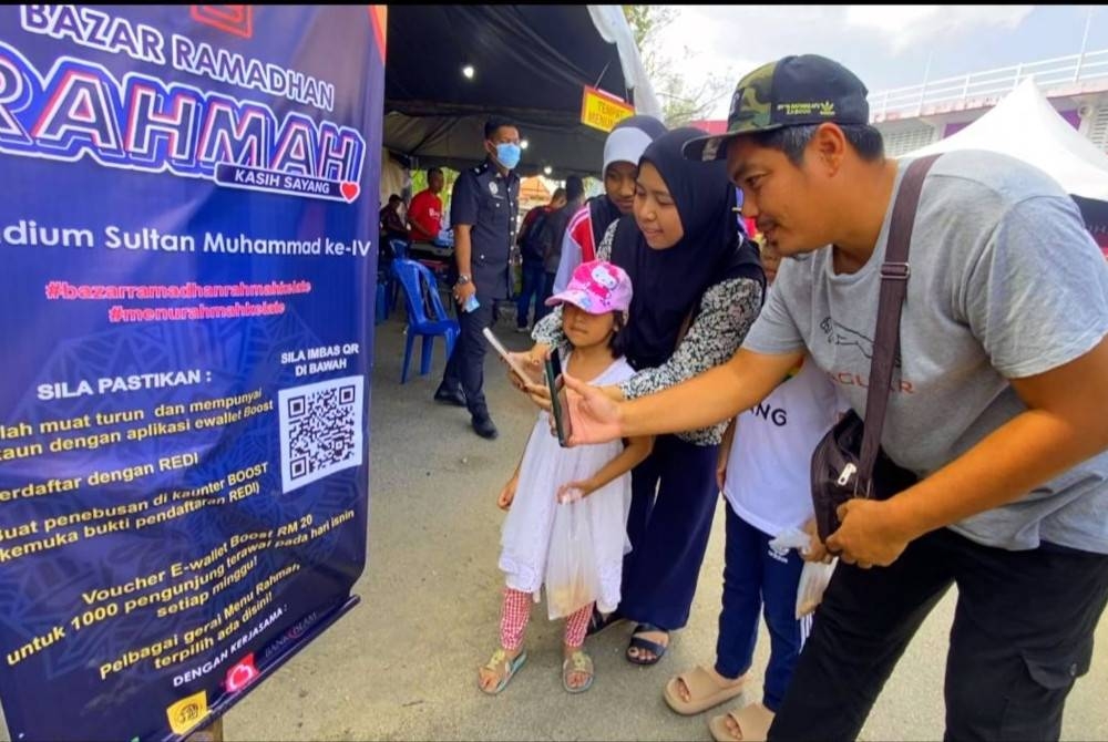 Pengunjung mengimbas kod QR bagi mendapatkan baucer e-dompet bernilai RM20 di Bazar Ramadan Rahmah, Stadium Sultan Muhammad IV, Kota Bharu.