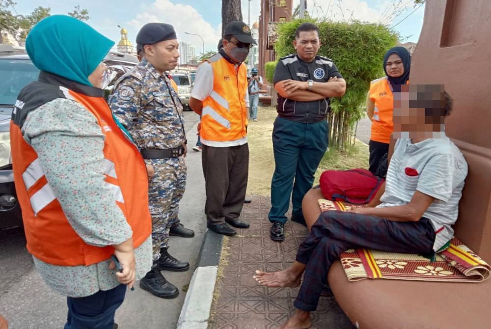 Samad (kanan) yang bangun dari tidur ketika dihampiri pasukan penguatkuasa pada Selasa.