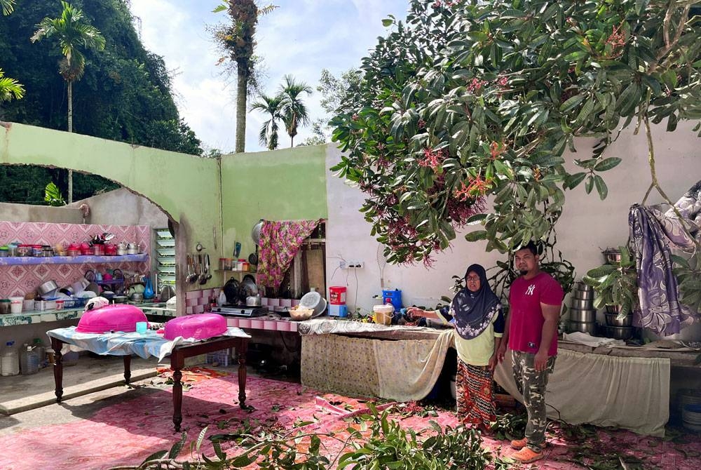 Hasmah (kiri) bersama anaknya, Mohd Farrez Haqimee menunjukkan keadaan rumah mereka selepas dibadai ribut petang semalam. - Foto Bernama