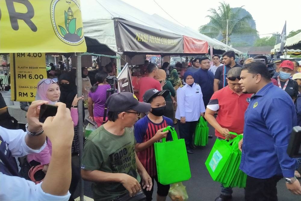 Muhamad Arafat (kanan) beramah mesra dengan pengunjung bazar Ramadan selepas menyempurnakan Majlis Pembukaan Bazar Ramadan Taman Perpaduan, Hulu Kinta pada Selasa.