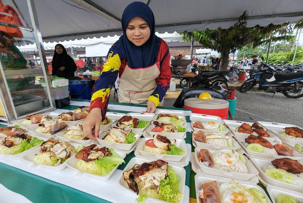 Azniza menyusun nai ayam di gerainya di bazar Ramadan Stadium Paroi.