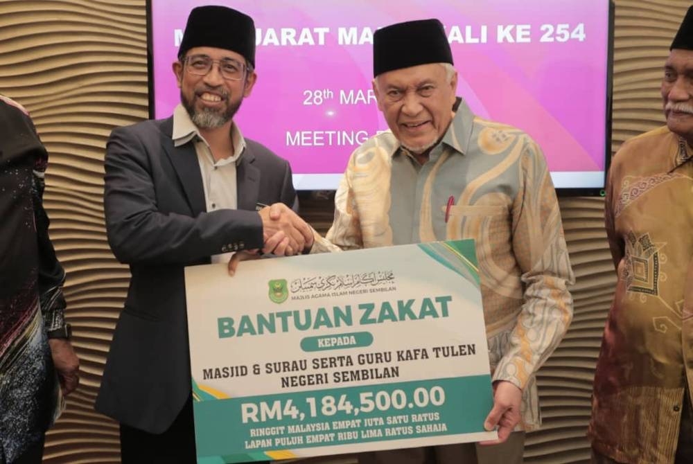 Abdul Aziz (kanan) ketika menyerahkan bantuan zakat.