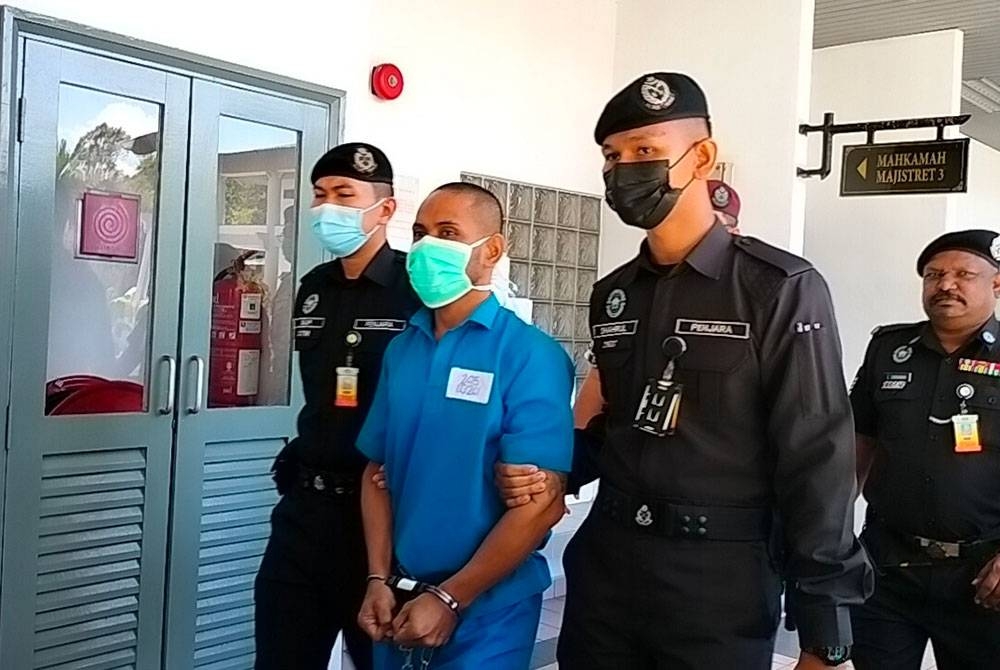 Mohd Fahrur Radzi (depan, tengah) ketika dibawa keluar dari Mahkamah Majistret Ayer Keroh pada Rabu.