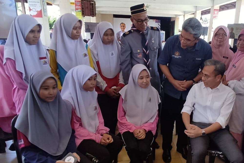 Fahmi (duduk kanan) bersama pelajar SMK Padang Terap selepas merasmikan Hab Rangkaian Gentian Optik Point of Presence (PoP) Zon Utara pada Rabu.