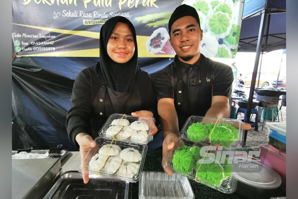 Muhd Hafiz dan isteri, Sakiinah menunjukkan dua perisa kuih putu perak iaitu perisan gula merah dan pandan yang dijual di Bazar Ramadan Drawbridge di Kuala Nerus, Terengganu.