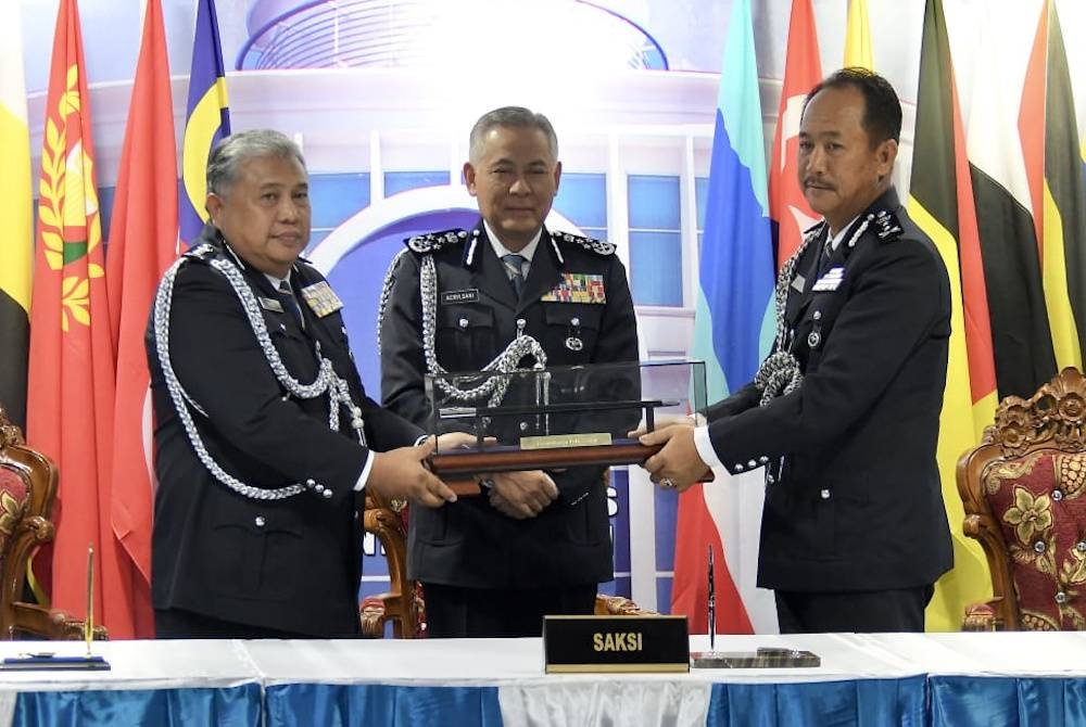 Acryl Sani (tengah) menyaksikan Majlis Serah Terima Tugas Pesuruhjaya Polis antara Idris (kiri) dan Jauteh (kanan) di IPK Sabah.